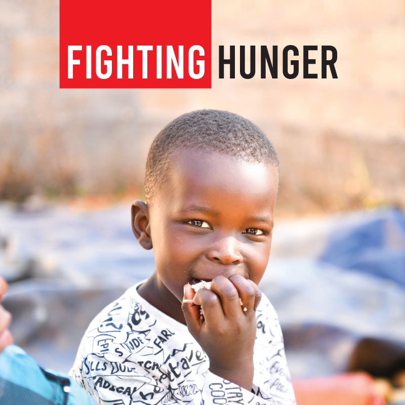 A child eating some food for fighting hunger button.