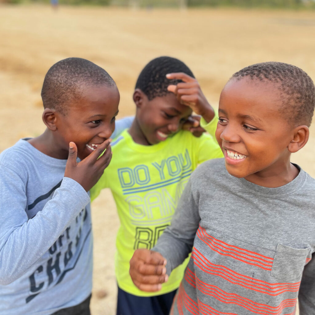 Three kids laughing together.